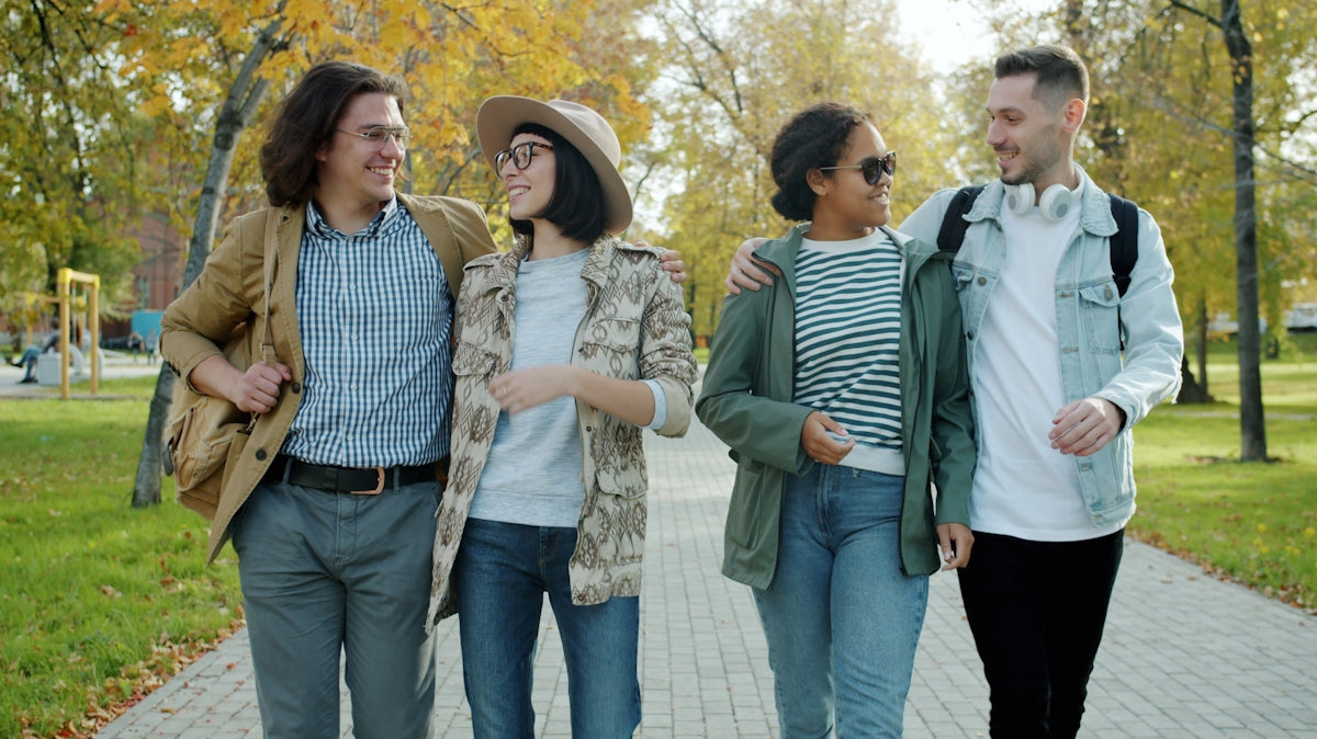 Four friends walking together in a park