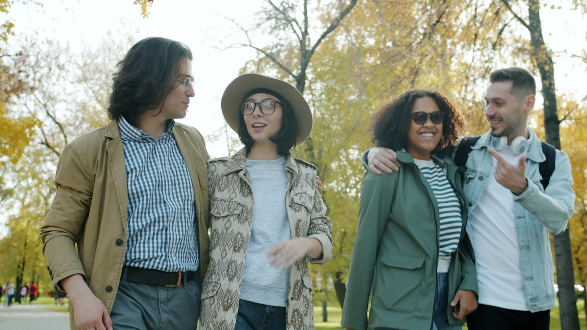 Four friends walking together in a park.