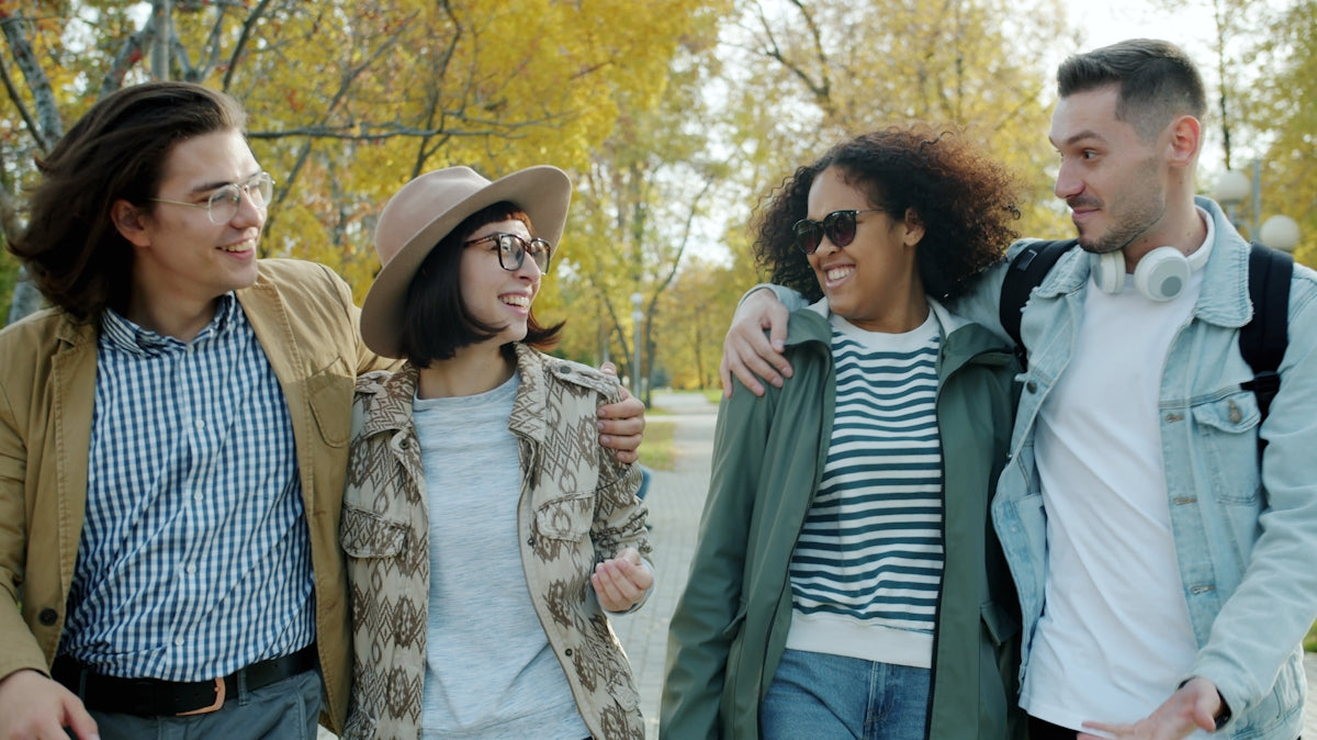 Four friends walking together in a park
