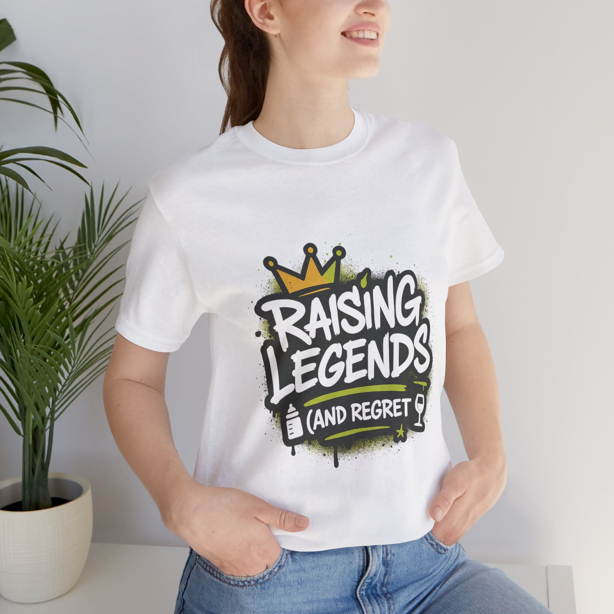 A person wearing a white t-shirt with the text "RAISING LEGENDS (and regret)"