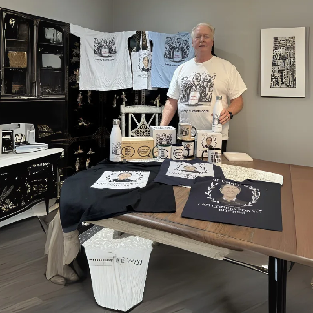 A table displays various merchandise including t-shirts, bottles, and boxes