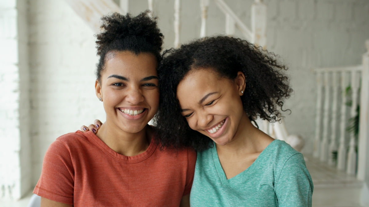 Two young women smiling together indoors