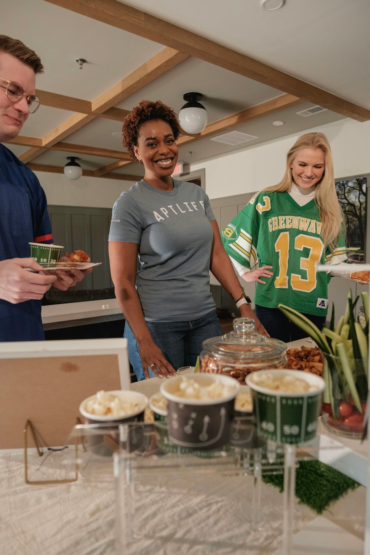 People gathered around a buffet table with food.
